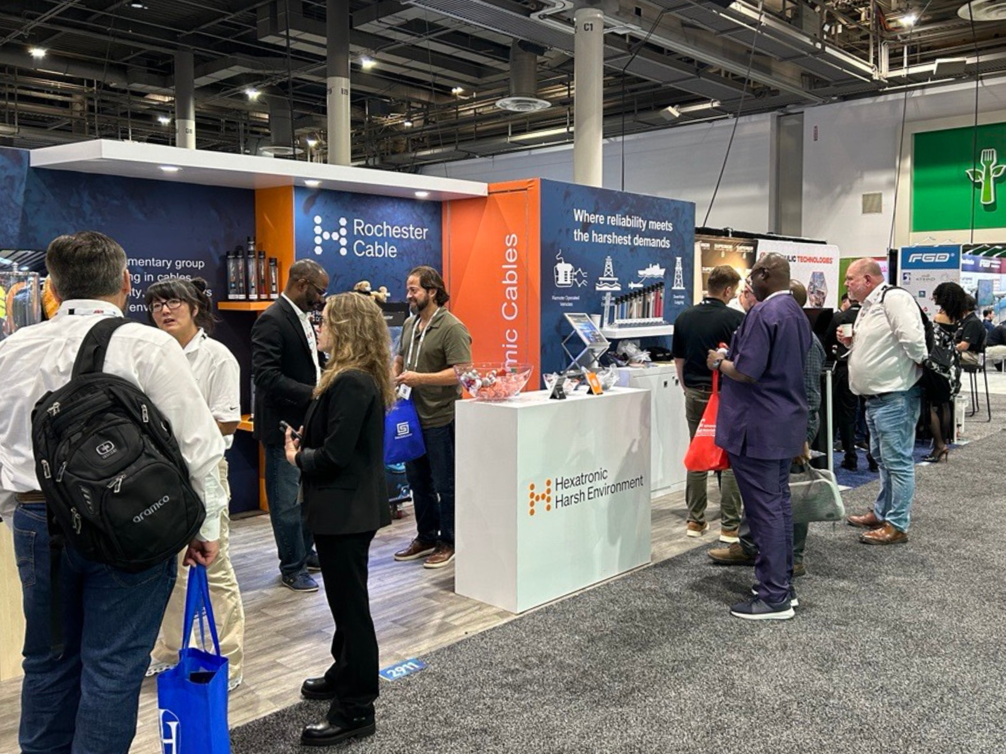 People interacting at a trade show booth for Rochester Cable.
