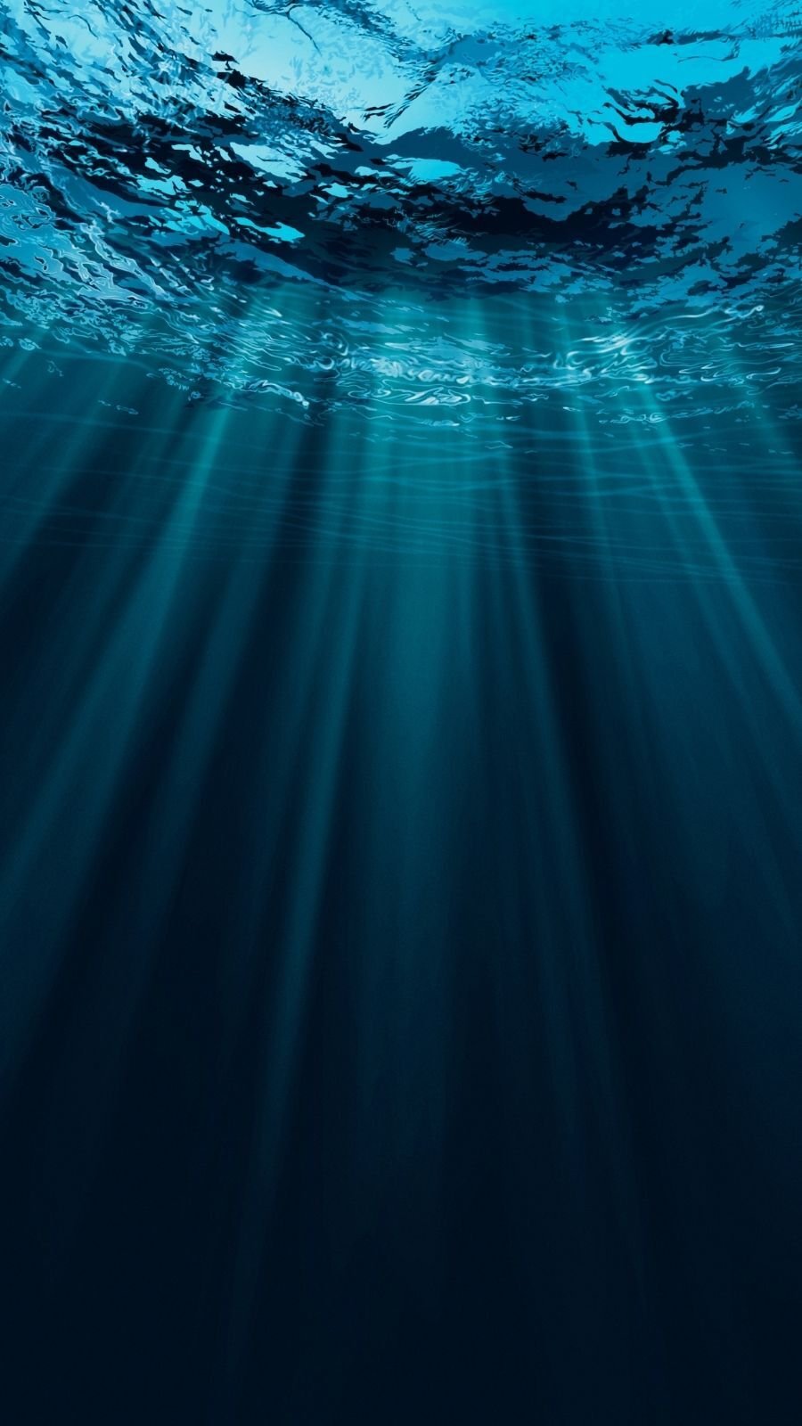 Sunlight filters through the blue ocean surface, creating ethereal beams that illuminate the deep, dark water below.