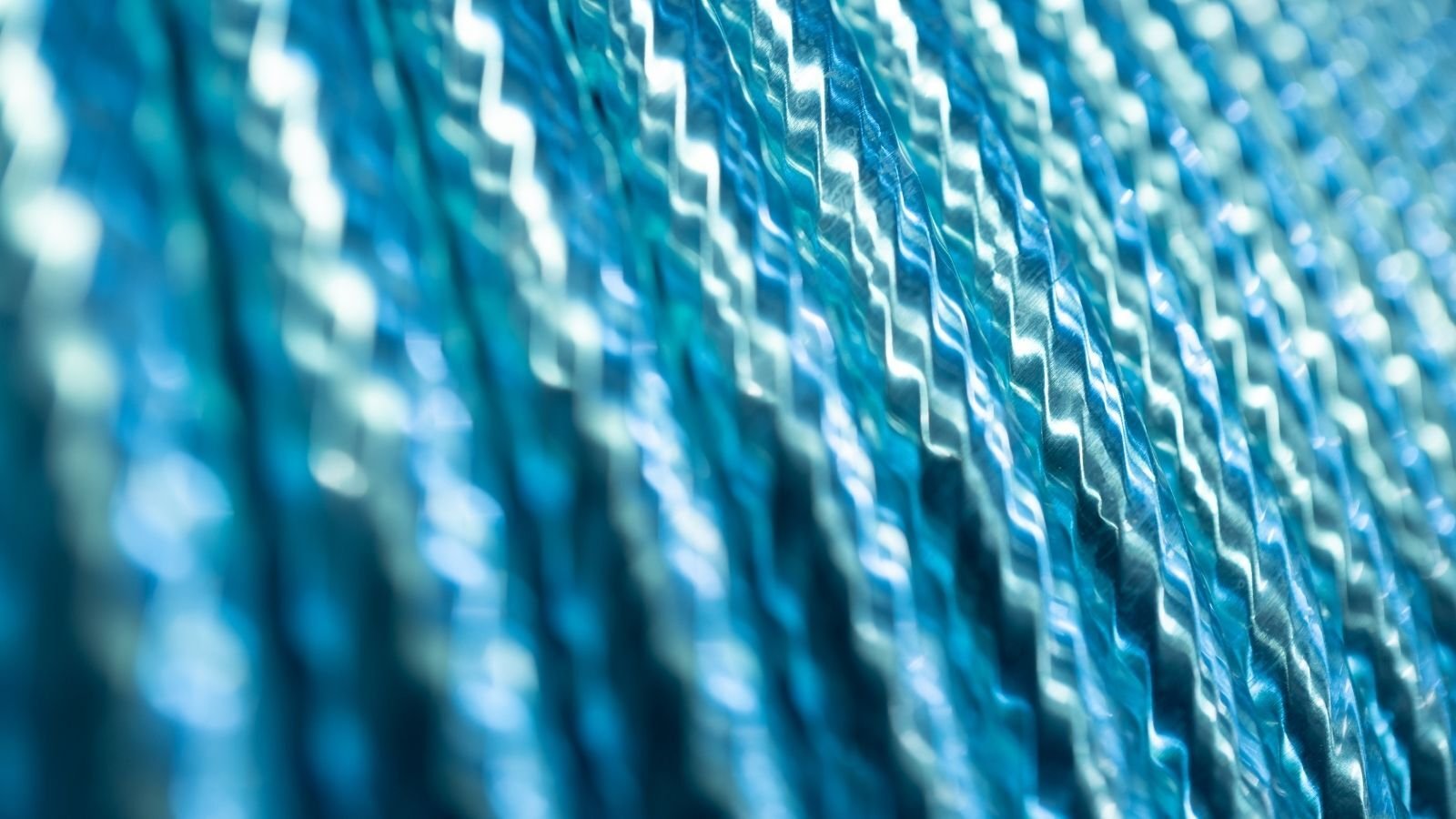 Close-up of shiny, textured blue waves, creating a diagonal pattern with a metallic sheen.